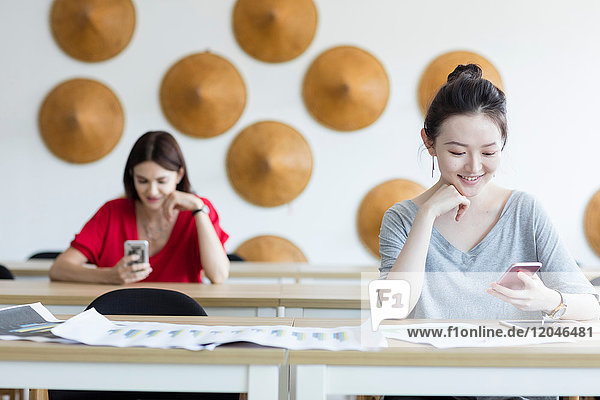Students using mobile phone while waiting in class