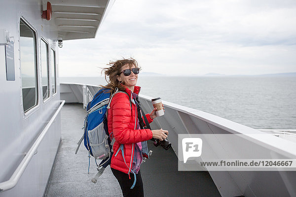 Porträt einer Frau auf der Fähre nach Vancouver Island  die Kaffeetasse und Kamera hält