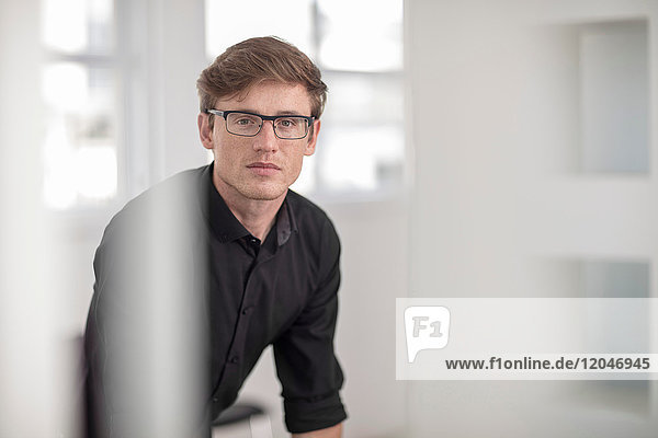 Porträt eines jungen männlichen Büroangestellten mit Brille