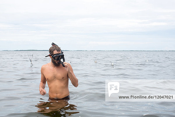 Man in water wearing snorkel mask