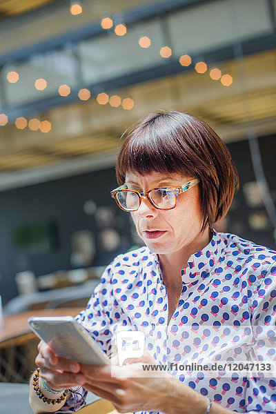 Frau im Büro mit Smartphone