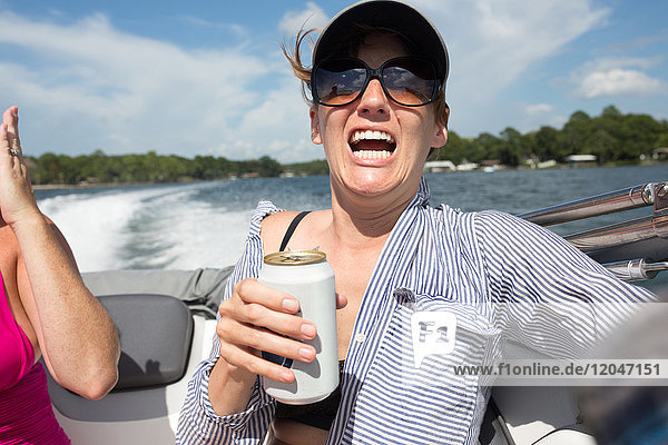 Woman on speedboat  holding beer  shocked expression