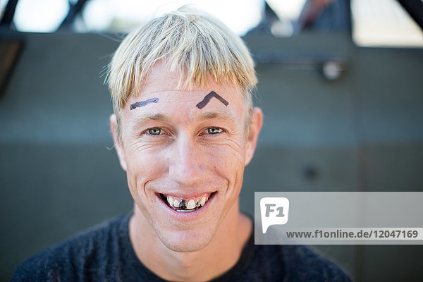 Porträt eines jungen Mannes mit schlecht geschnittenem Haar  auf Augenbrauen gezeichnet und geschwärzten Zähnen