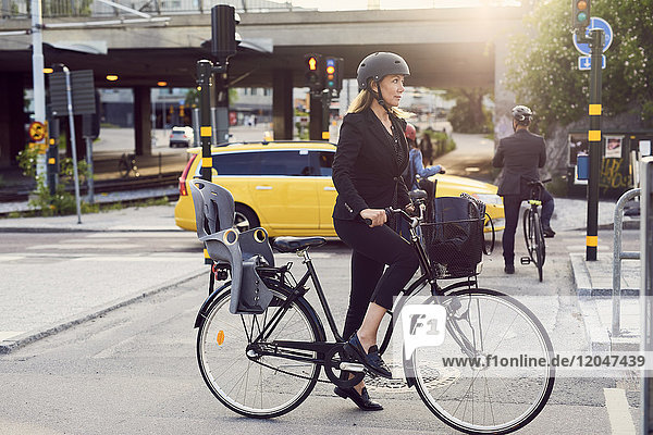 Reife Geschäftsfrau mit Fahrrad auf der Straße in der Stadt
