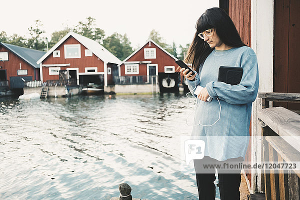 Frau mit Smartphone im Stehen am See