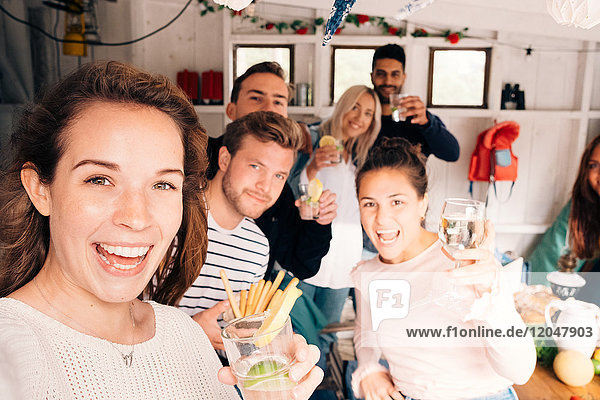 Porträt von Freunden mit Essen und Trinken im Ferienhaus