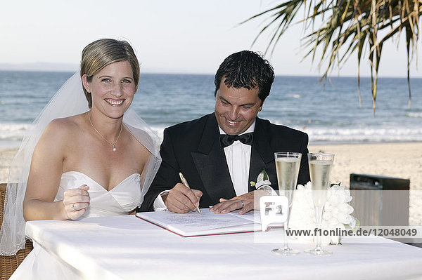 Paar beim Unterzeichnen von Heiratsurkunden  Noosa Beach  Australien