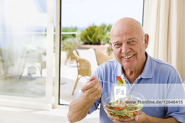 Porträt eines Mannes,  der Salat isst