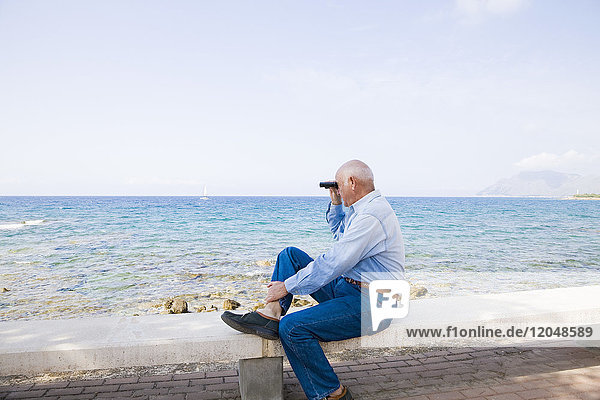 Man Looking Out to Sea With Binoculars