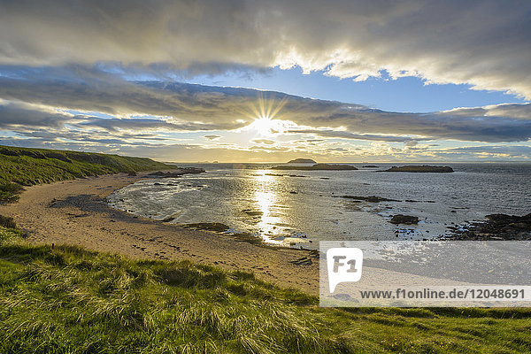 Sun shining over bay with sandy beach at sunset in North Berwick at Firth of Forth in Scotland United Kingdom