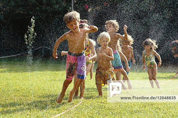 Spielende Kinder im Sprinkler