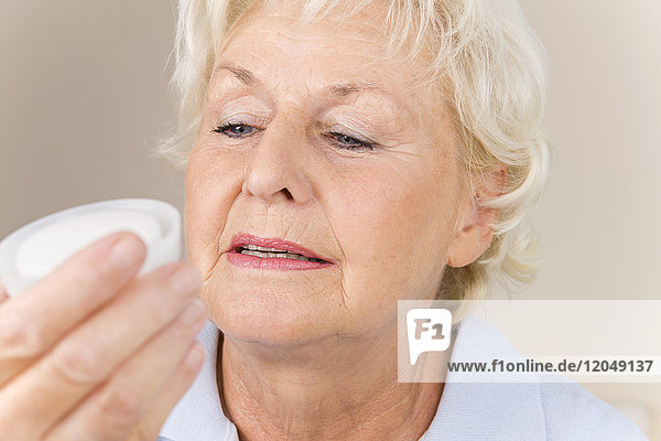 Frau liest Inhaltsstoffe auf Produkt