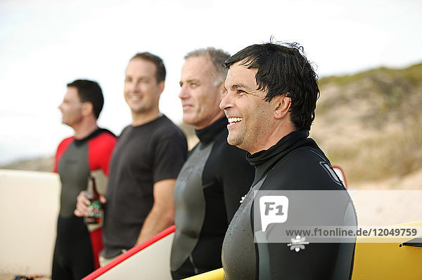Männer am Strand mit Surfbrettern