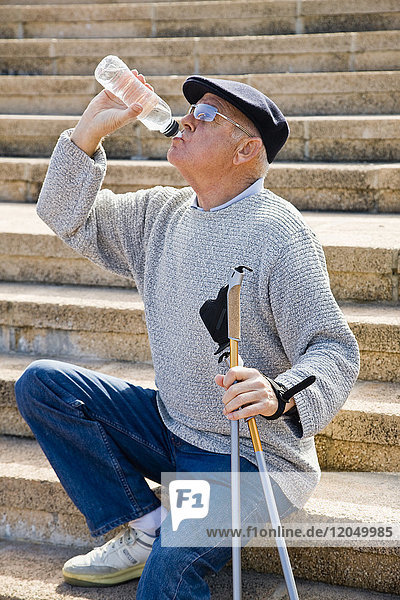 Nordic Walker Taking a Break and Drinking Bottled Water