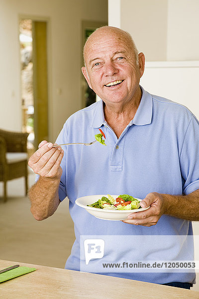 Porträt eines Mannes  der Salat isst