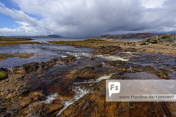 Rocky shoreline of a river flowing into the sea bay on the Isle of Skye in Scotland  United Kingdom