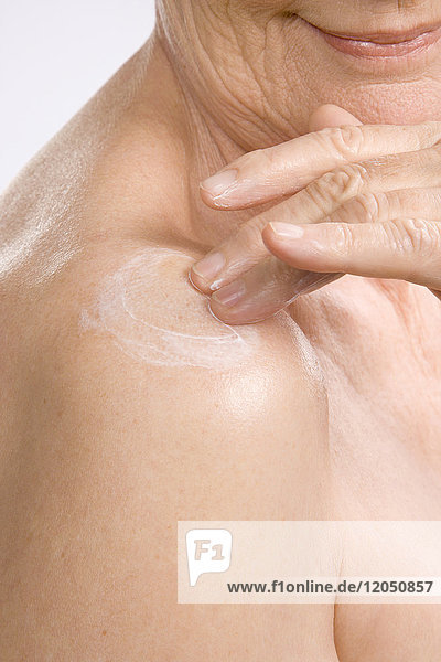Close-up of Woman Rubbing Lotion on Shoulder