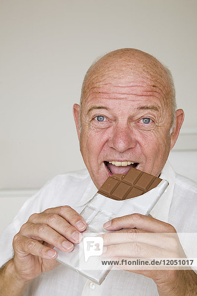 Mann isst Schokoladenriegel