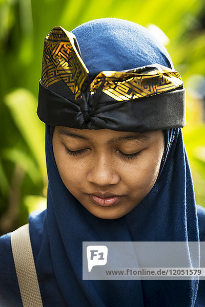 Eine junge balinesische Frau posiert bei einer hinduistischen Zeremonie; Bali  Indonesien