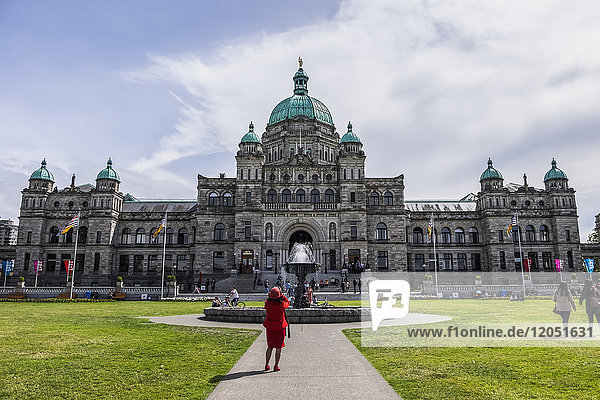 Eine Dame in Rot fotografiert das Parlamentsgebäude von British Columbia; Victoria  British Columbia  Kanada