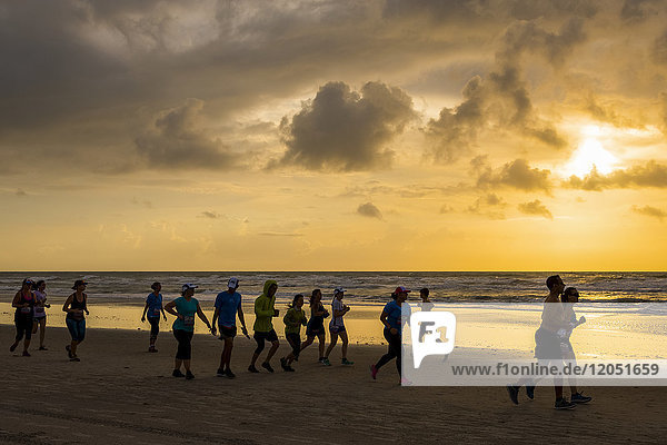Läufer laufen bei Sonnenaufgang am Strand während der USA Beach Running Championships 2017; Cocoa Beach  Florida  Vereinigte Staaten von Amerika