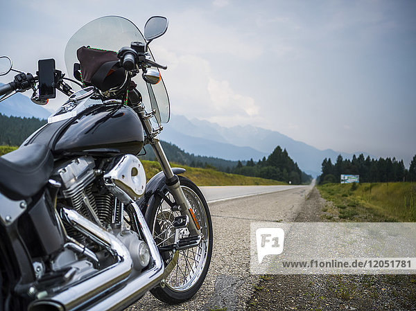 Ein am Straßenrand geparktes Motorrad mit Blick auf die Berge in der Ferne; Spillmacheen  British Columbia  Kanada
