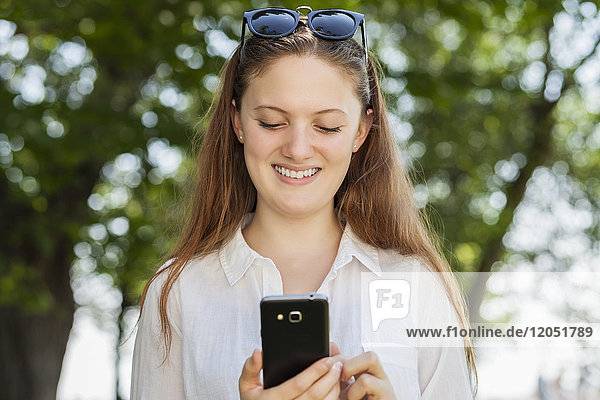 Teenage girl using her smart phone  Woodbine Beach; Toronto  Ontario  Canada