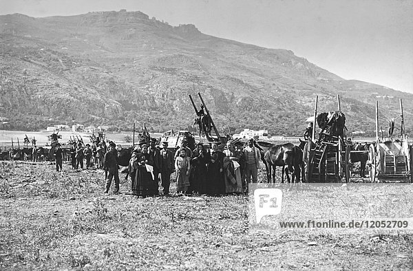 Ein Vintage-Schwarz-Weiß-Bild von einer großen Gruppe von Menschen mit ihren Pferden und Kutschen stehen