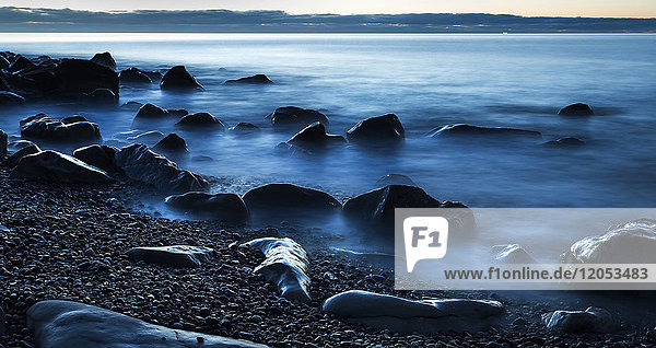 Schöner blauer  nebliger Ozean  der an einem Strand an der Westküste gegen Felsen spült; Greymouth  Neuseeland
