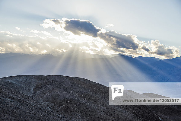 Lichtströme hinter einer Wolke im Death Valley National Park  in der Nähe des Artists' Drive; Kalifornien  Vereinigte Staaten von Amerika