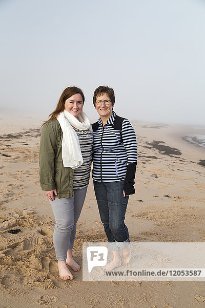 Porträt einer Mutter und ihrer Tochter  die barfuß an einem Strand im Nebel stehen; Prince Edward Island  Kanada