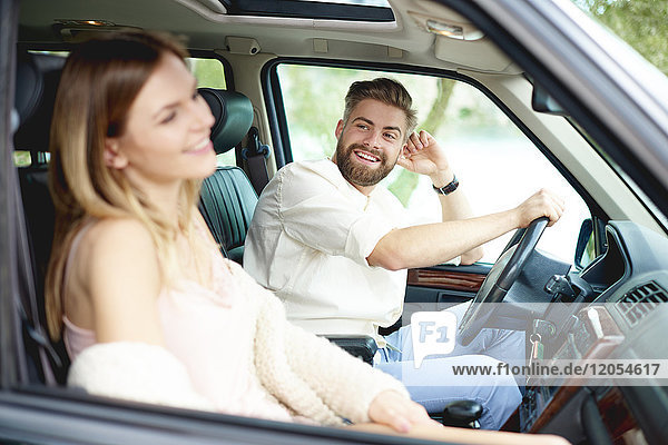 Happy young couple in car
