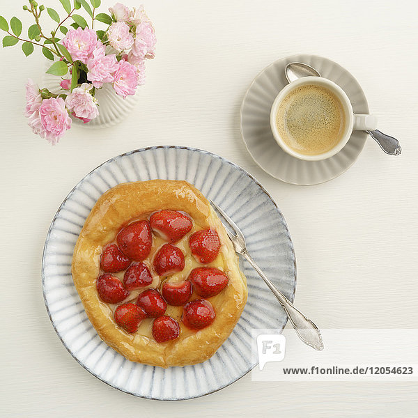 Blumen  Kaffee und Plundergebäck mit Erdbeeren und Vanillepudding
