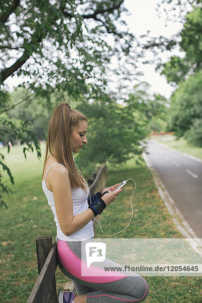 Sportliche Frau bei einer Pause im Park