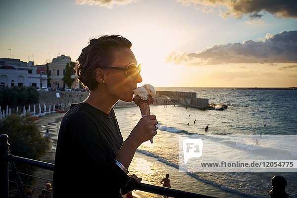 Italien  Santa Maria al Bagno  Frau beim Eis essen im Gegenlicht