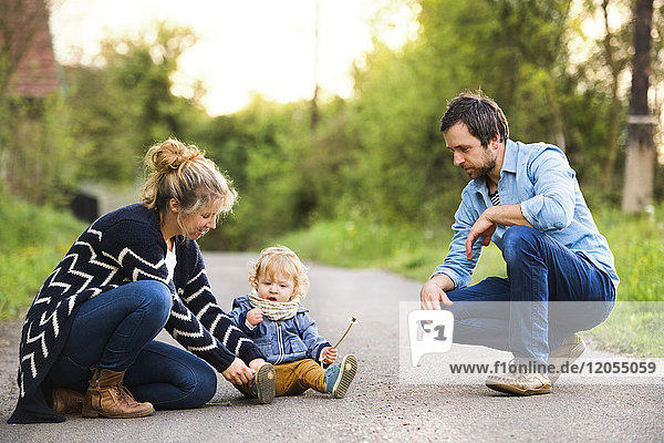 Cute little boy with parents on field path