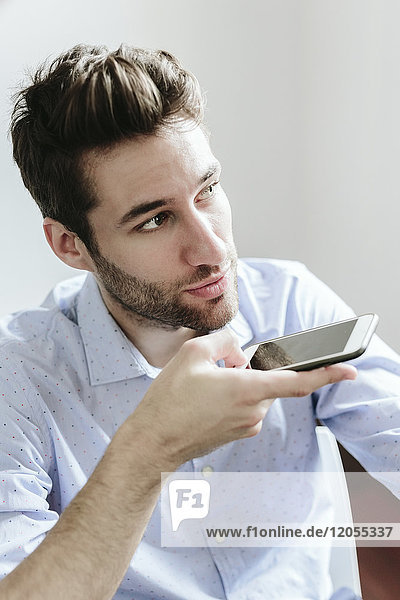 Young businessman working in office using smartphone