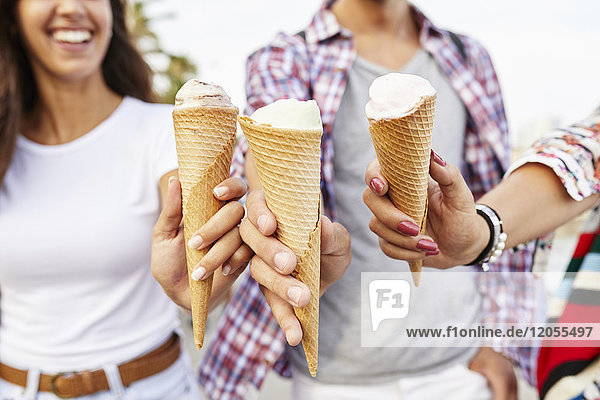 Close-up of three friends holding ice cream cones
