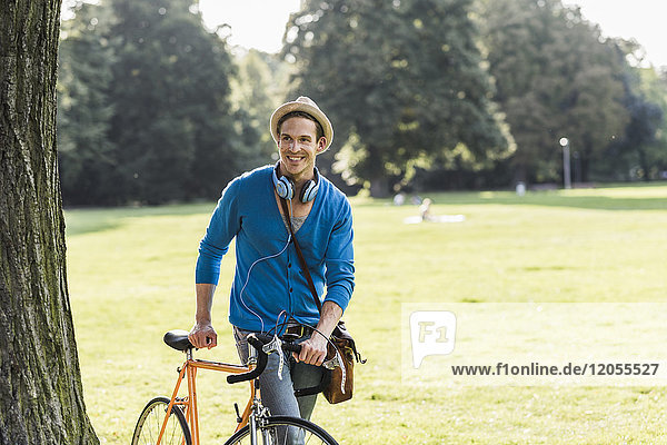 Porträt eines entspannten Mannes mit Rennrad im Park