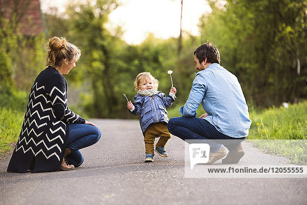 Cute little boy with parents on field path
