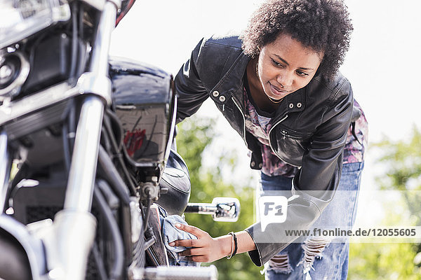 Junge Frau reinigt ihr Motorrad
