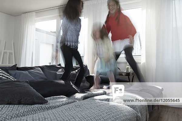Mädchen springen auf Sofa im Wohnzimmer