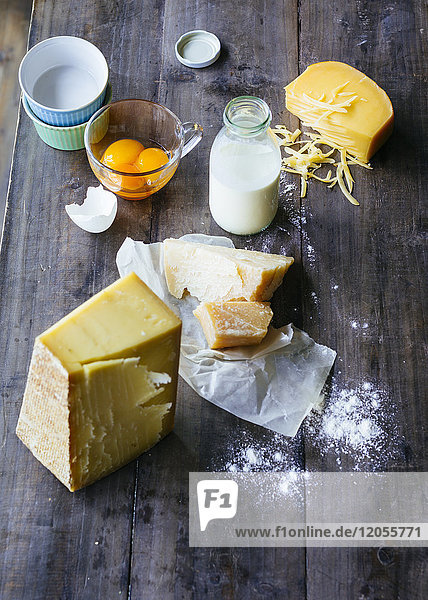 Flasche Milch  Käse und Glas Eigelb auf Holz