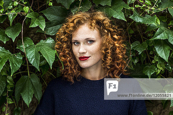 Portrait of redheaded young woman with red lips