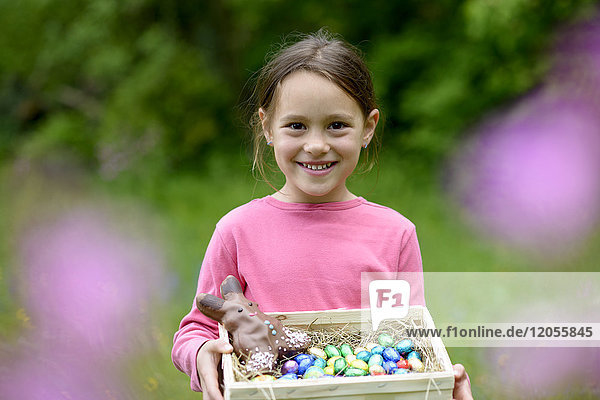Porträt eines fröhlichen kleinen Mädchens mit Osternest