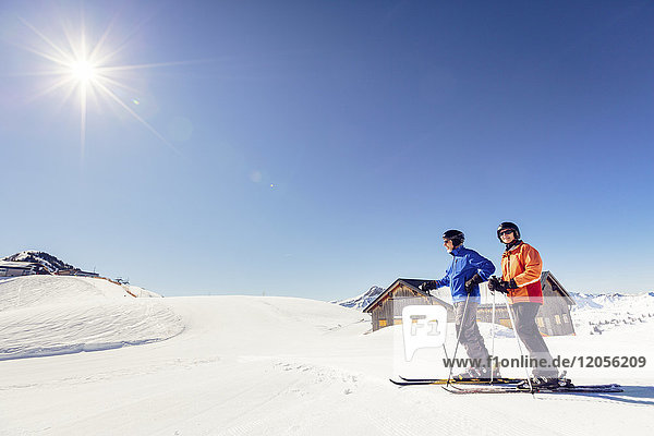 Österreich  Damuels  Paar mit Skifahrern in Winterlandschaft