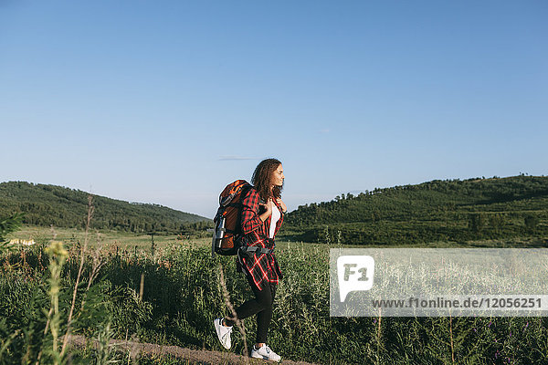 Teenage girl with backpack hiking in nature