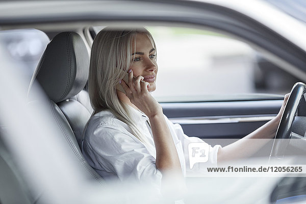 Geschäftsfrau am Handy beim Autofahren