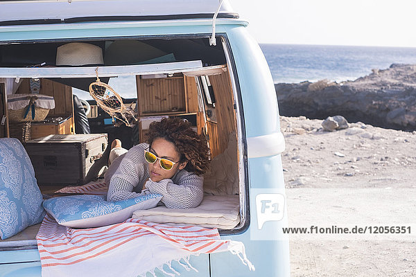 Spanien  Teneriffa  Frau entspannt in einem Van am Meer geparkt