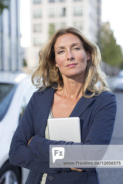 Porträt einer selbstbewussten Geschäftsfrau mit Tablette in der Stadt